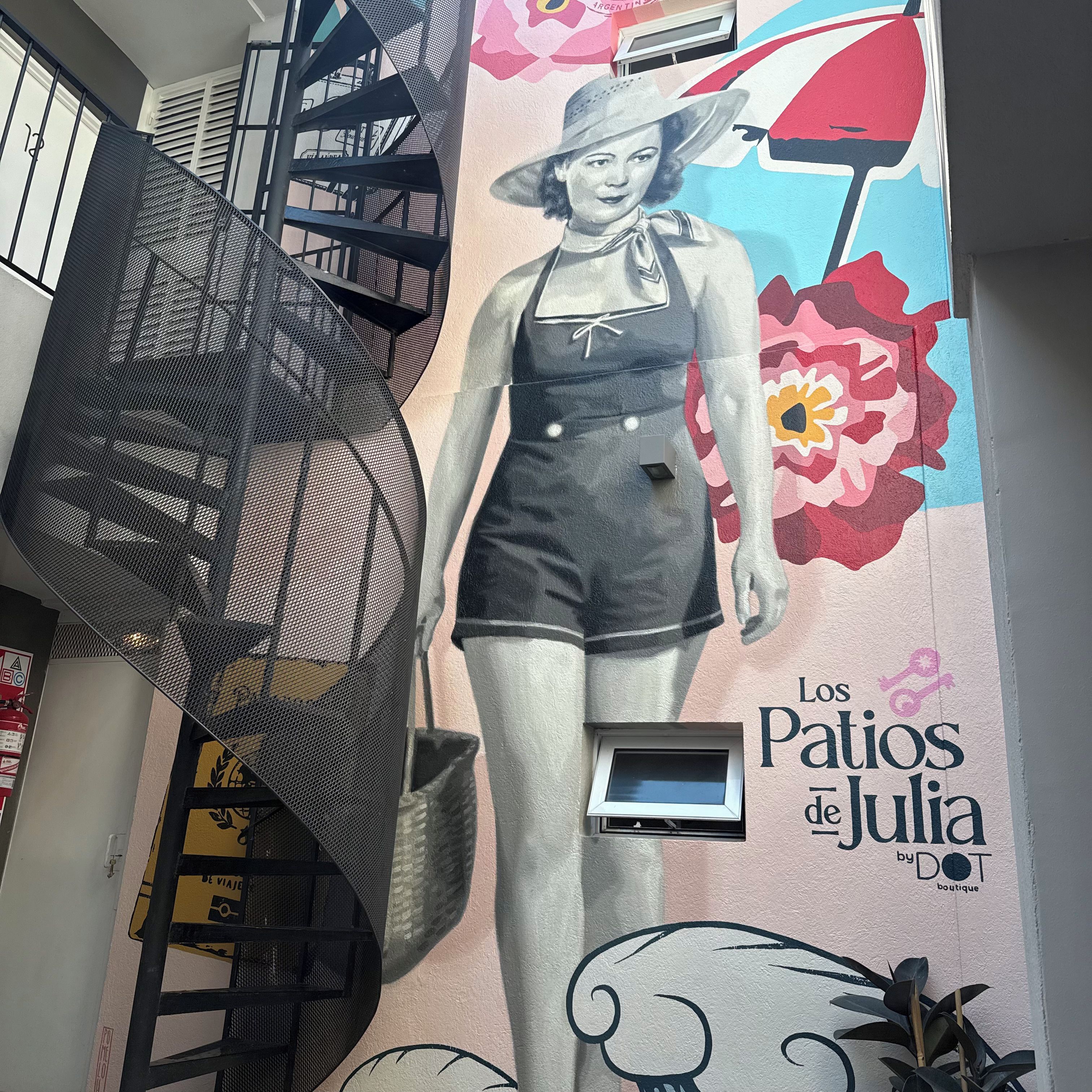 A mural with a woman in shorts and a hat, a fire extinguisher, and a window.