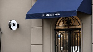 A building entrance with a blue awning labeled 'Los Patios de Julia' and a circular sign with 'DOT Boutique' on the wall. - Los Patios de Julia by DOT Boutique (Buenos Aires)