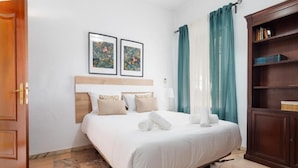 Ein Hotelzimmer mit einem Bett, einem Holzkopfteil, einem Bücherregal und zwei gerahmten Bildern an der Wand.