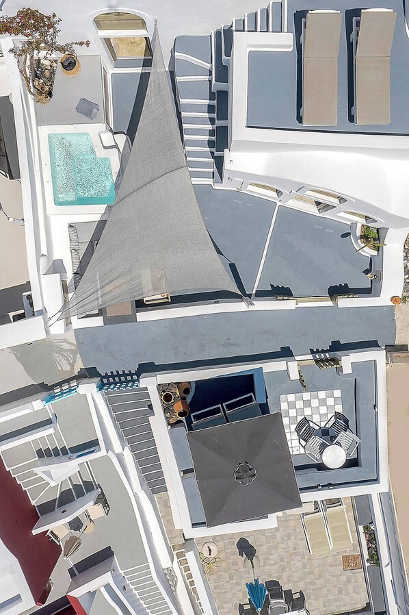 A rooftop terrace with a swimming pool, outdoor seating, and a distinctive pyramid-shaped structure. - Chess House - Santorini Traditional Home (Santorini)