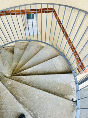 Eine Wendeltreppe mit Metallgeländern und einer Ziegelwand.