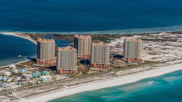 A coastal hotel complex with multiple high-rise buildings, beachfront access, and a marina. - Luxury Portofino Condo | Panoramic Water Views | Pools, Spa & Beach (Pensacola Beach)