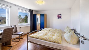 Un dormitorio con una cama, un escritorio y una silla.