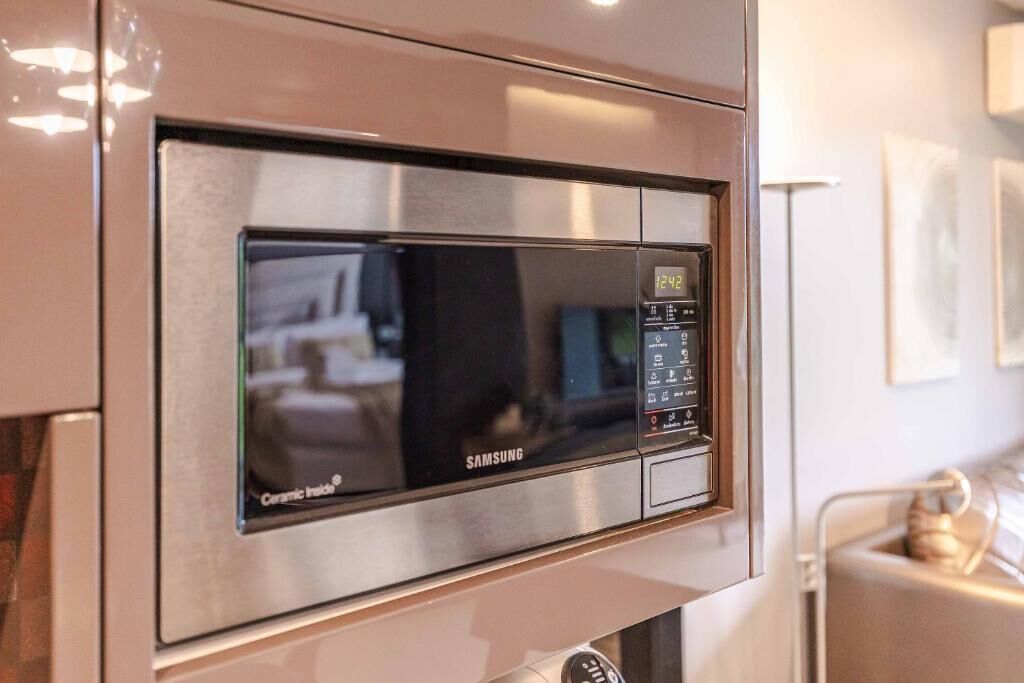 En Samsung-mikrovågsugn med digital display, knappar för inställningar och en etikett med texten ”Keramisk insida”.