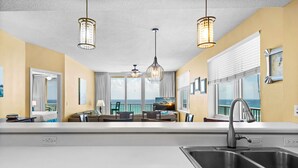 A modern kitchen with a large island, stainless steel sink, and pendant lighting. - 🌴🩴Gulf-Front 3BR | Steps to Navarre Beach Pier | Summerwind Center 504 (Navarre Beach)