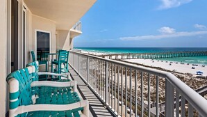 A balcony with chairs and a view of the beach and pier. - 🌴🩴Gulf-Front 3BR | Steps to Navarre Beach Pier | Summerwind Center 504 (Navarre Beach)