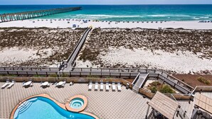 A beach resort with a swimming pool, sun loungers, and a pier extending into the ocean. - 🌴🩴Gulf-Front 3BR | Steps to Navarre Beach Pier | Summerwind Center 504 (Navarre Beach)