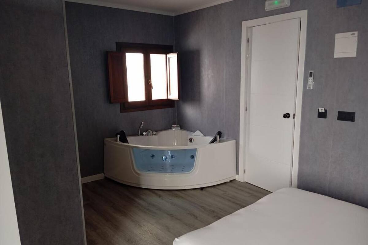 A modern bathroom with a bathtub, a mirror, and a door.