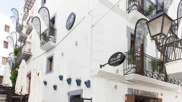 A white building with outdoor seating, a stone facade, and a sign for 'La Selección de Boda'. - La sepia Boba (Peñíscola)