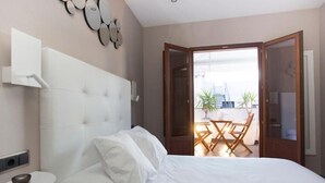 A bedroom with a bed, bedside table, and a view of an outdoor patio with a table and chairs. - La sepia Boba (Peñíscola)