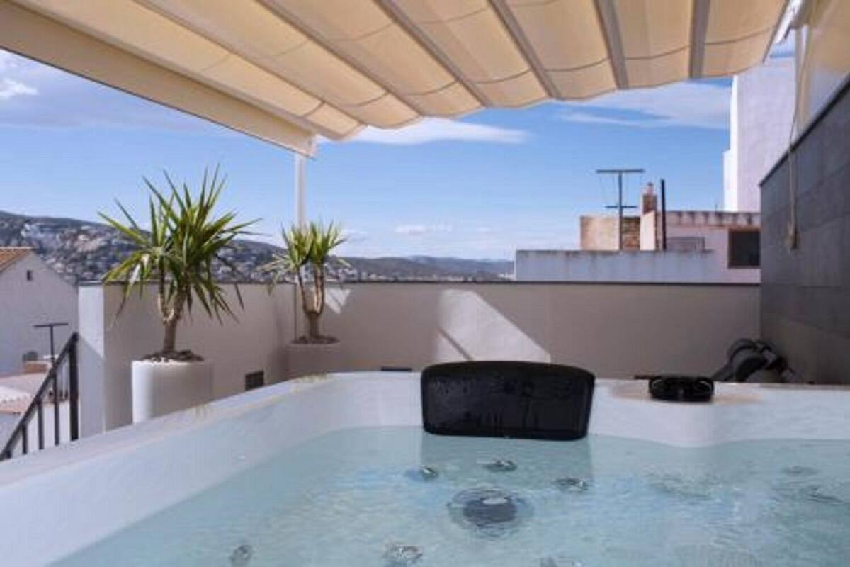 A rooftop hot tub with a view of the cityscape.
