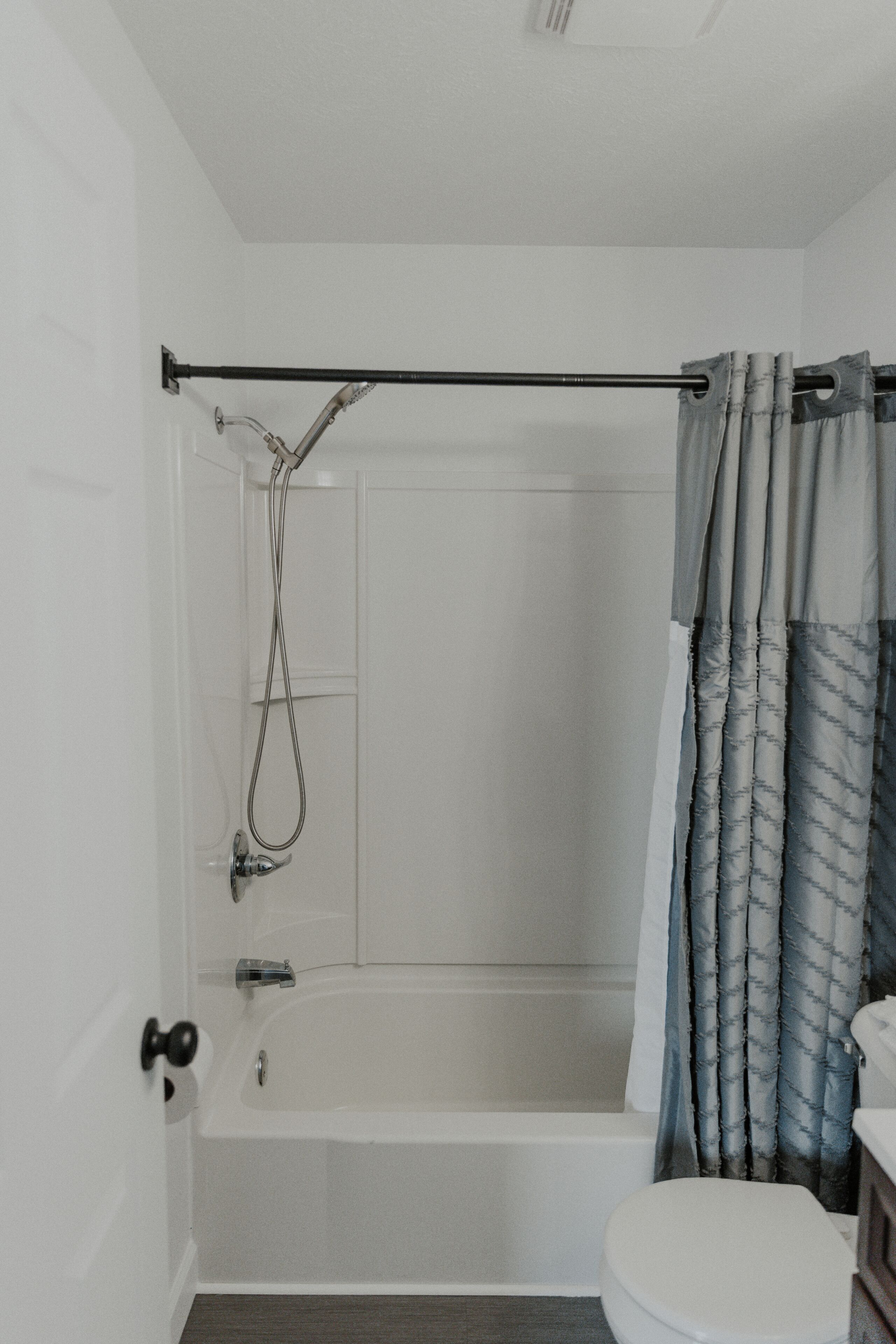 Un baño con bañera, inodoro y cortina de ducha.