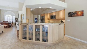 Una cocina con una isla central, armarios de madera y un microondas.