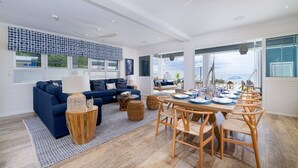 Un salon moderne comprenant un canapé, une table basse et un coin repas avec des chaises.