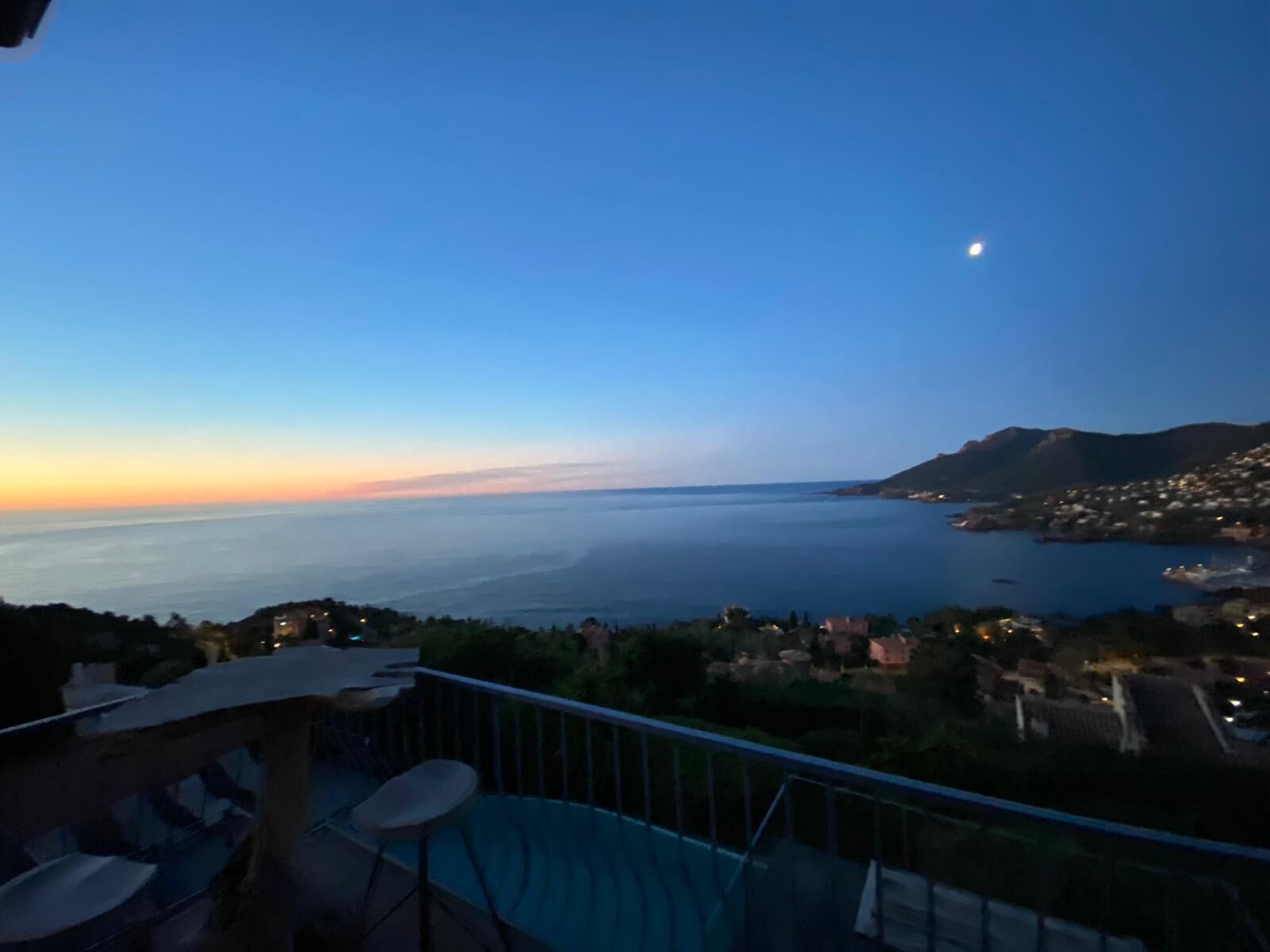Un balcon offrant une vue sur un paysage côtier au crépuscule.
