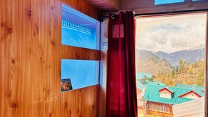 A wooden interior with a window revealing a mountainous landscape. - Dolma homestay by Orko (Nichar)