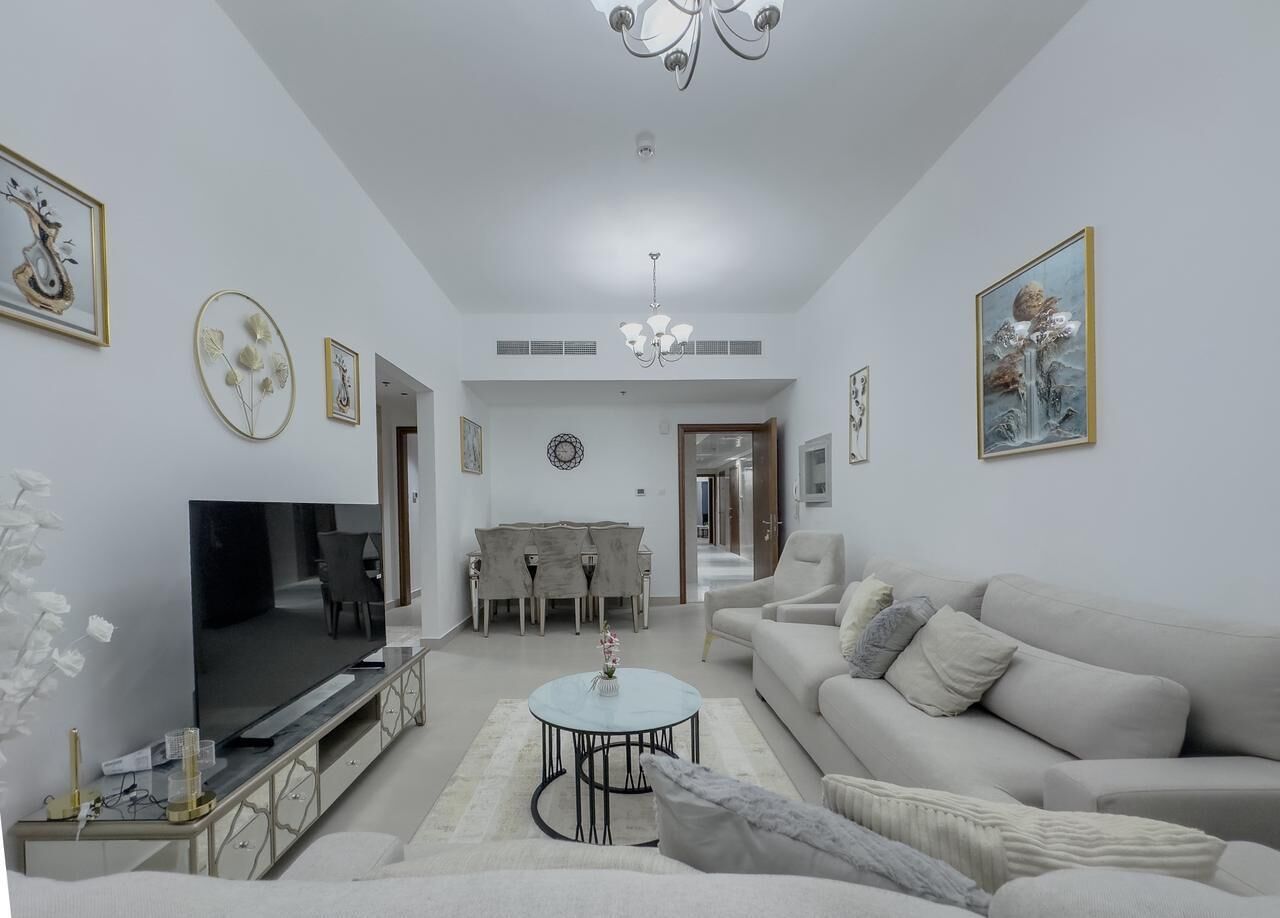Ein Wohnzimmer mit Fernseher, einer Couch, einem Couchtisch und einem Essbereich.