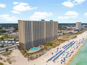 Ein Hochhaus-Hotel mit Pool und Zugang zum Strand.