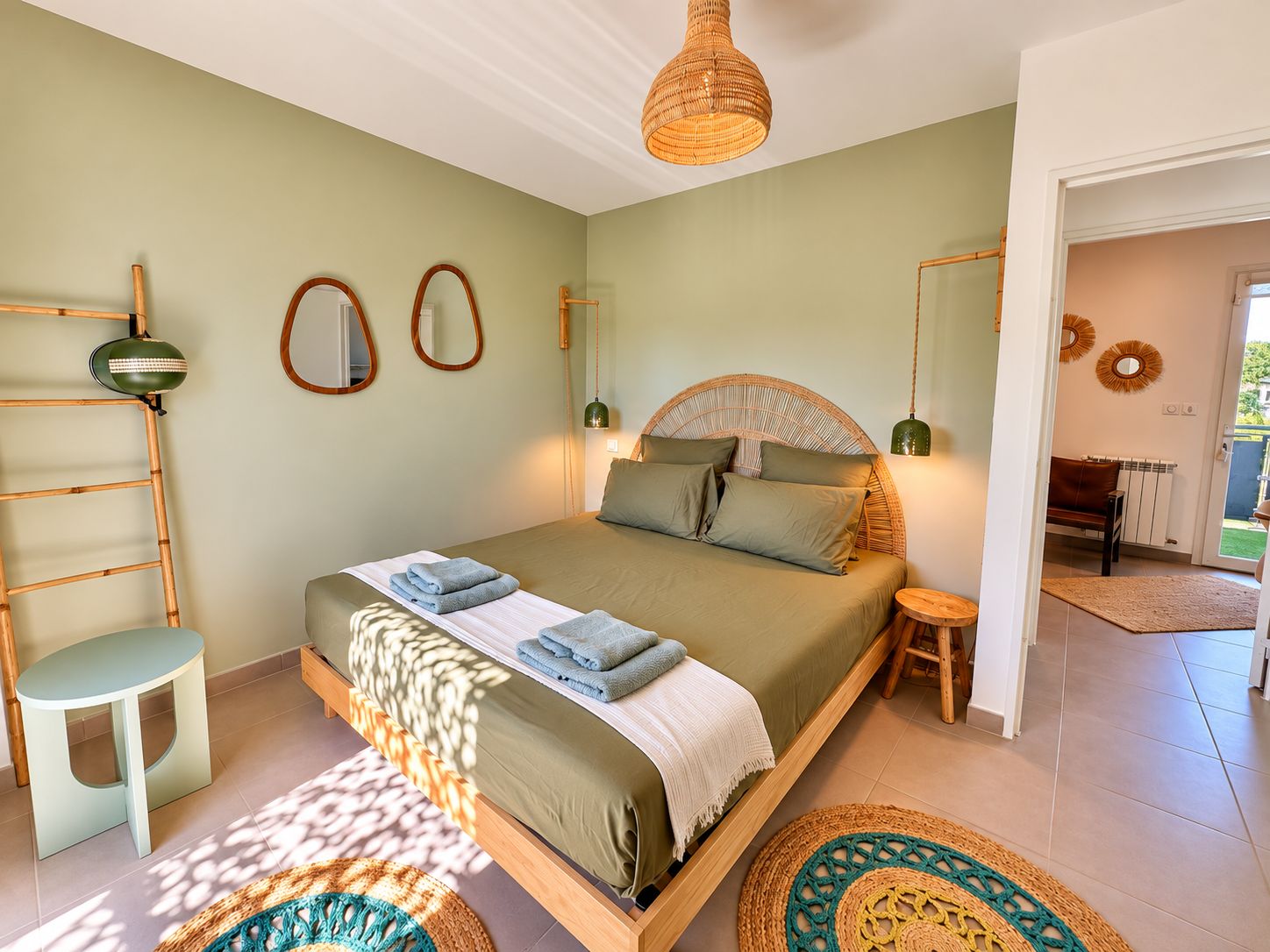 Une chambre bien éclairée, avec un lit, des tables de chevet, une armoire et une vue sur l’extérieur.