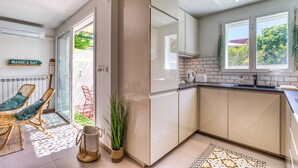 A modern kitchen with a sliding glass door leading to a patio, a built-in oven, and a view of the outdoors.