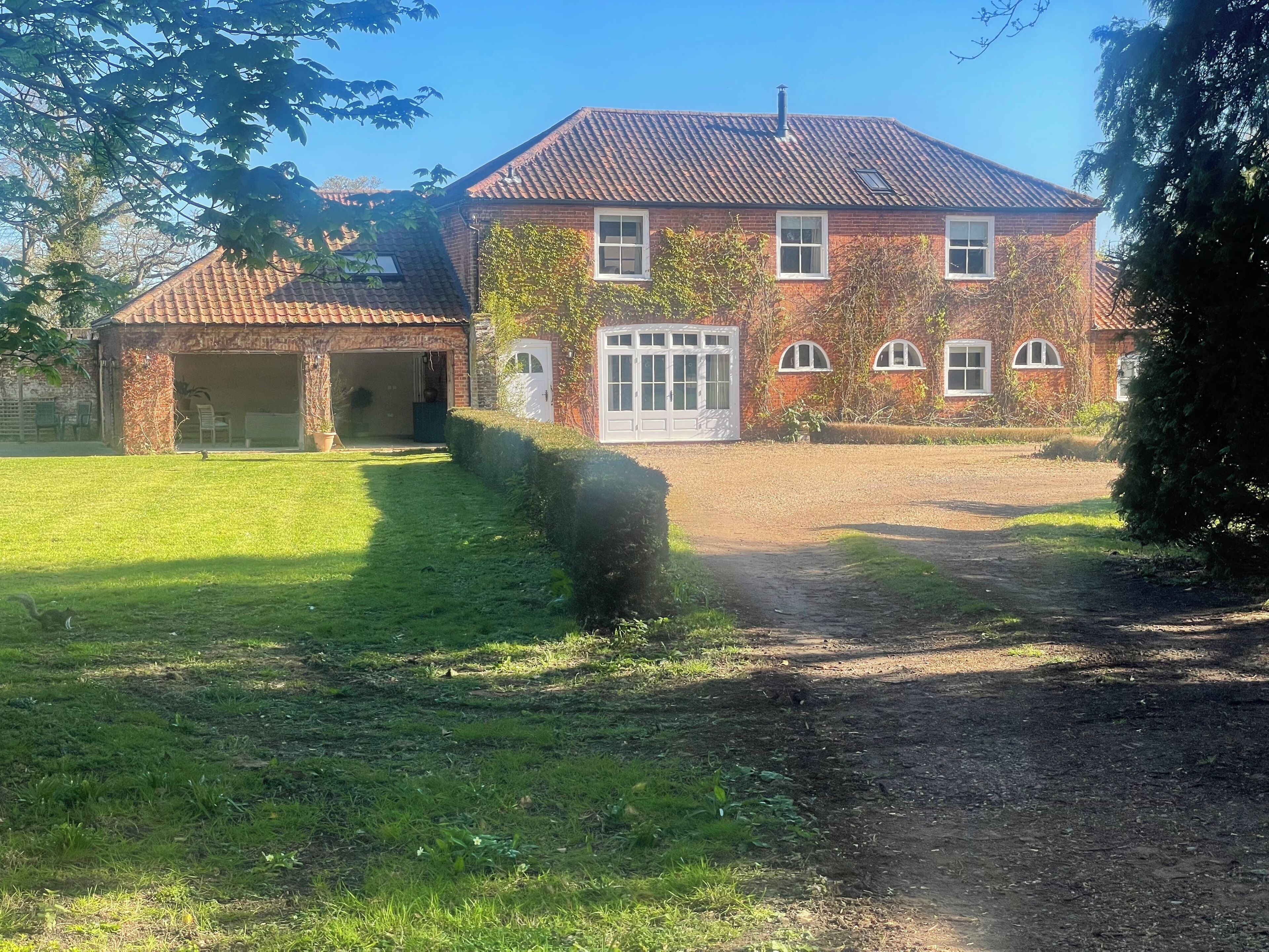 A brick house with a garage, a front door, and a paved driveway.