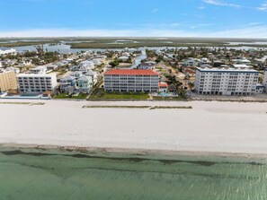Ein Hotel an der Küste mit einem zentralen Gebäude, einem Pool und Blick auf den Strand.