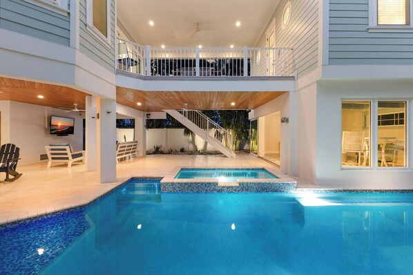 A two-story house with a swimming pool, a balcony, and a staircase leading to the upper floor. - Prana Sanctuary: Luxury 4 Bedroom Home in Heart of Anna Maria (Anna Maria)
