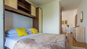 Een slaapkamer met een bed, een kledingkast, een bureau en een spiegel.