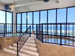 A staircase with caution signs, large windows, and a view of the beach. - Phoenix I 1076- Ahhhmazing View! Gulf Front! Best Amenities! 5 Stars! (Orange Beach)