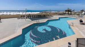 Une piscine à la forme en spirale, des chaises longues attenantes et une vue sur la plage.