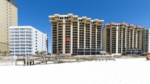 Un hôtel situé en bord de mer, composé de plusieurs immeubles de grande hauteur, doté d’une promenade et d’une plage.