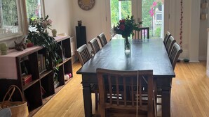 A dining room with a large wooden table, chairs, a hanging light fixture, and a view through the windows. - Family home in Saint-Lambert (Saint-Lambert)