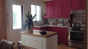 A kitchen with pink cabinets, a stove, and a sink. - Family home in Saint-Lambert (Saint-Lambert)