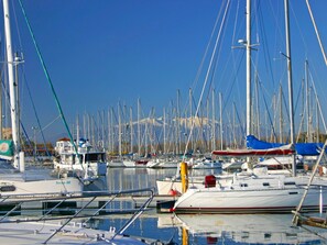 A marina with multiple boats docked, a clear sky, and a mountain in the background. - Mauclair by Interhome (Saint Cyprien)