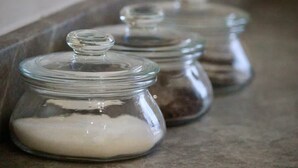 Cuatro frascos de vidrio con tapas sobre una bandeja metálica.