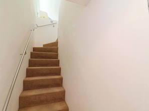 A staircase with carpeted steps and a metal handrail. - 12 Nautilus (Bideford)