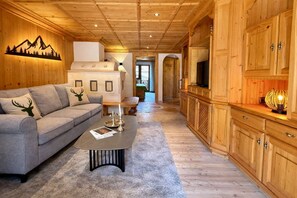 Ett mysigt vardagsrum med en soffa, ett soffbord och träskåp.