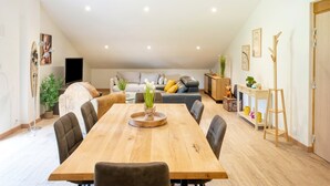 A spacious loft with a dining area, seating, and a loft bed.