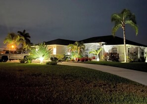 A residential house with a driveway, palm trees, and a vehicle parked outside. - Salted Sunset at Punta Gorda Isles (Punta Gorda)