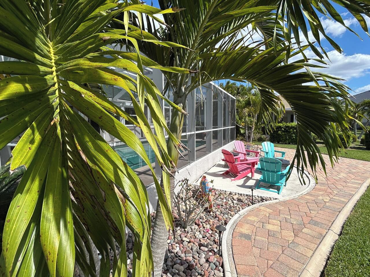 A patio area with outdoor seating and a pool in the background.