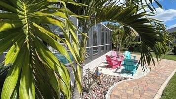 A patio area with outdoor seating and a pool in the background.