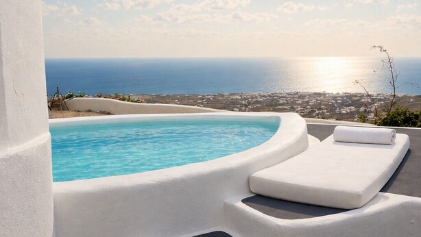 Ein Pool mit sonnigem Blick auf das Meer und einem weißen Bauwerk.