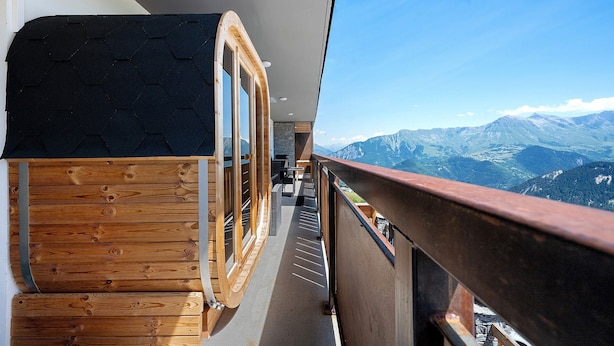 A wooden balcony with a view of mountains.