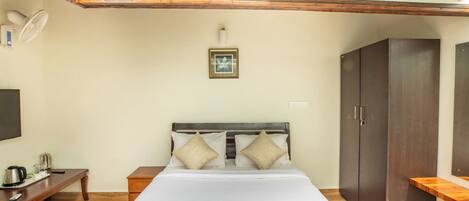 Un dormitorio con una cama grande, cabecera de madera, mesita de noche y un armario.