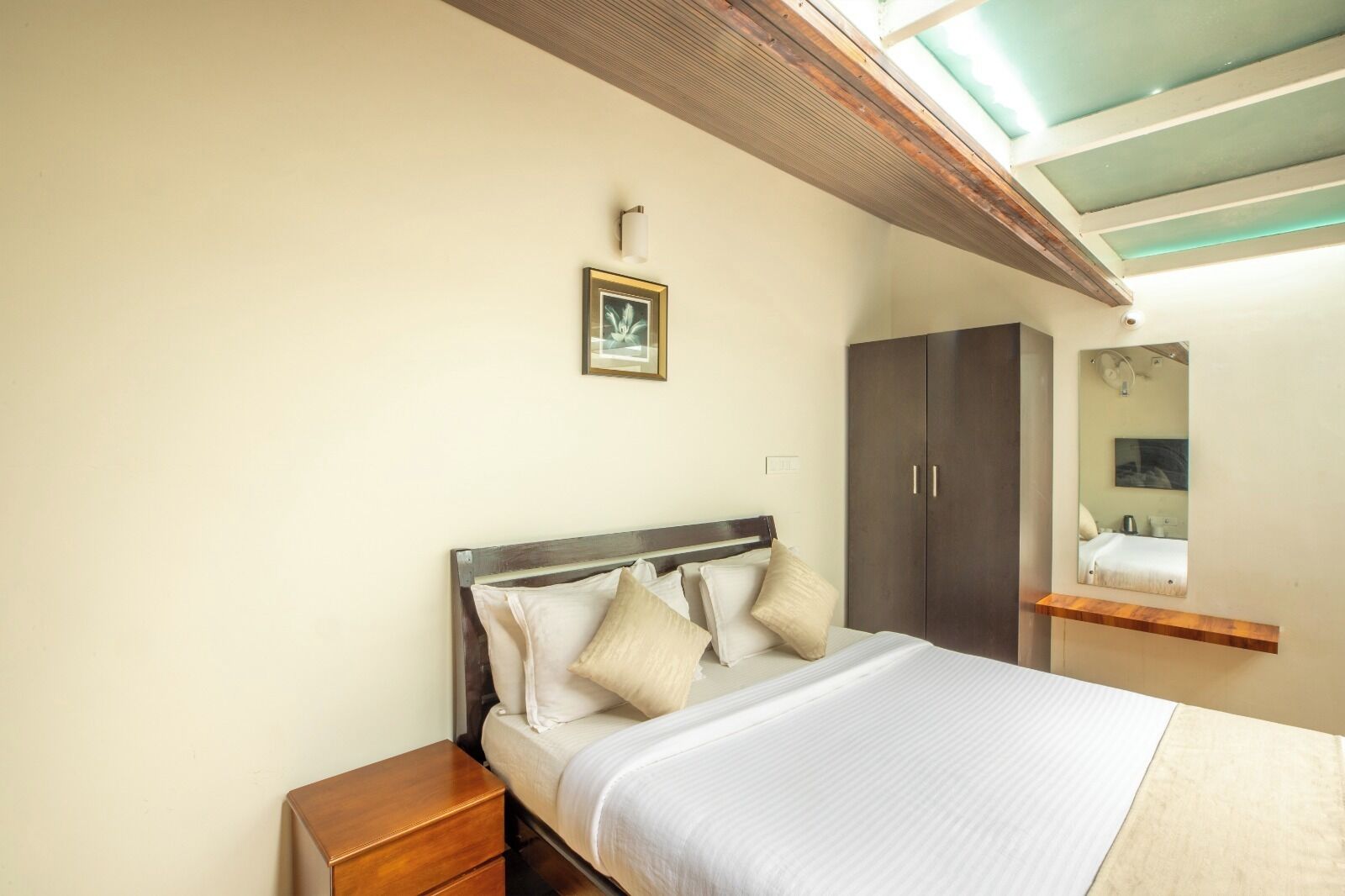 Ein Schlafzimmer mit Bett, Nachttisch, Kleiderschrank und Spiegel.