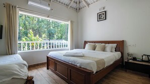A bedroom with a wooden bed, a window with a view of greenery, and a ceiling fan. - KAVA RETREAT (Chikkamagaluru)