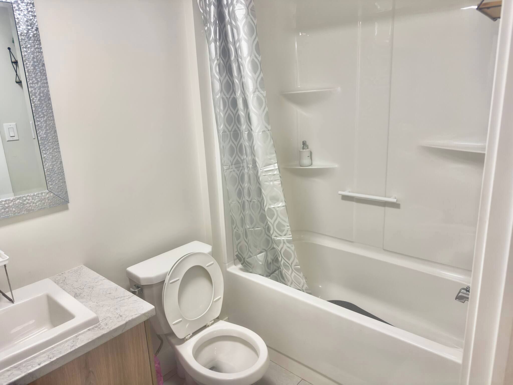 A bathroom with a toilet, sink, and shower.