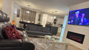 Un salon moderne avec un canapé, une table basse et un téléviseur fixé au mur.