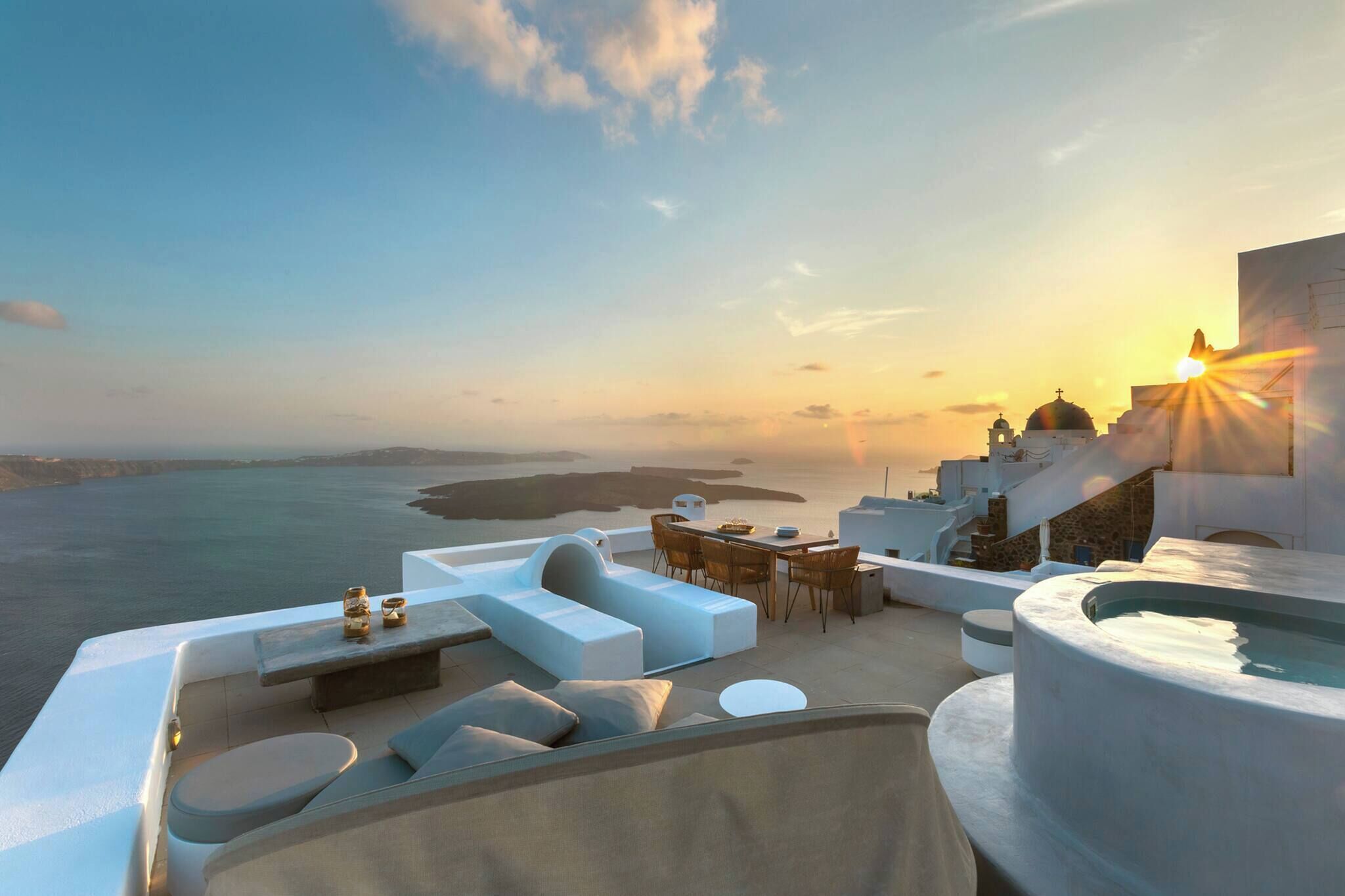 A rooftop terrace with a pool, seating area, and a view of the sea and buildings.