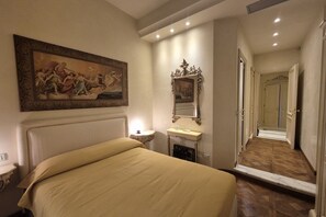 A hotel room with a bed, a painting, a mirror, a sink, and a hallway leading to another room. - Exclusive luxury penthouse located in Piazza D’Azeglio in Viareggio, on the third floor with elevator, featuring high-end finishes and a stunning panoramic sea-view terrace.The apartment, approximately 110 sqm, is arranged over two levels and enhanced  (Viareggio)